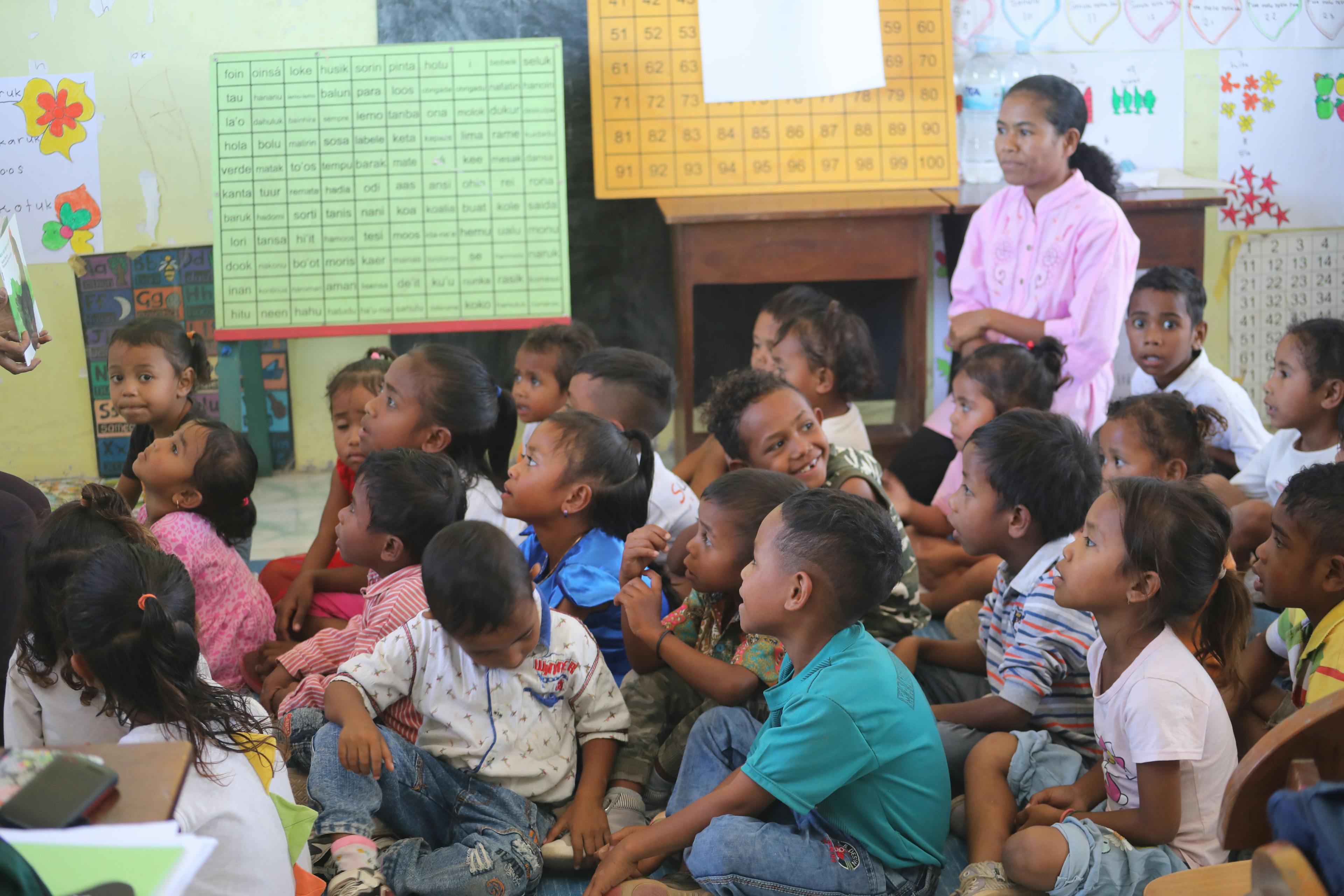 Story time: Children at Hi Preschool listening to their teacher read a story to them on the mat.