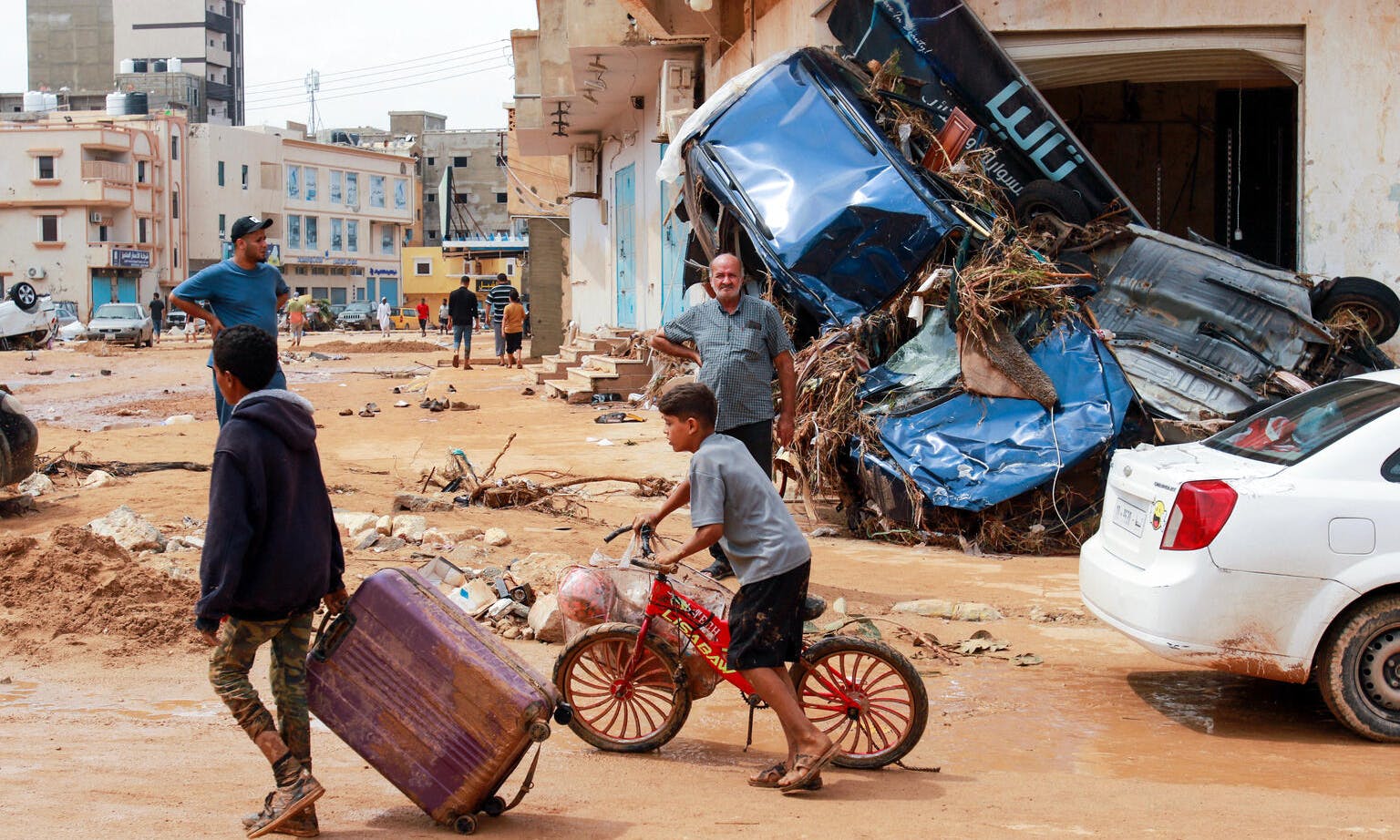 A boy pulls a suitcase past debris in a flash-flood damaged area in Derna, eastern Libya. Flash floods on September 11, 2023 have killed more than 2,300 people.