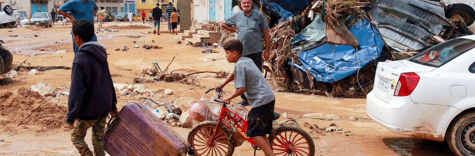 A boy pulls a suitcase past debris in a flash-flood damaged area in Derna, eastern Libya. Flash floods on September 11, 2023 have killed more than 2,300 people.