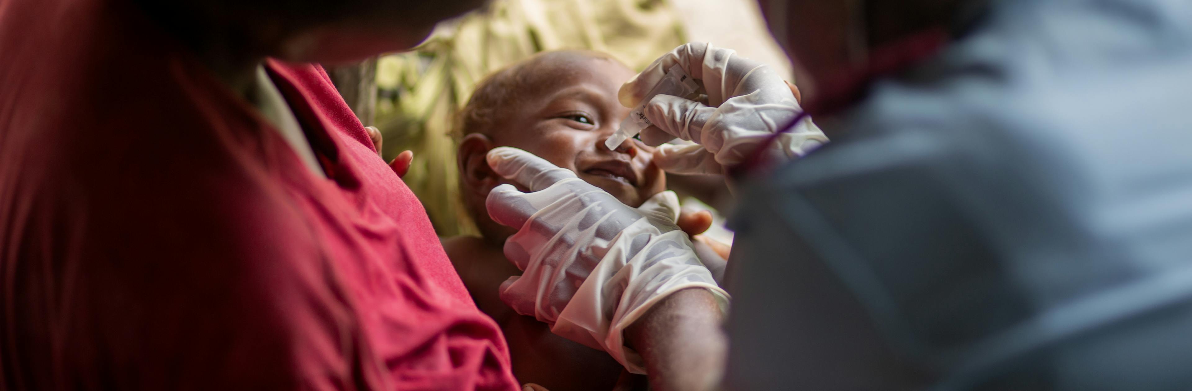 Peter is comforted by his mother, Senovevo, while Nurse Rosemary Raikekeni provides him a dose of rotavirus vaccine in Kuvamiti, East Guadalcanal, Solomon Islands, on 17 May 2023.