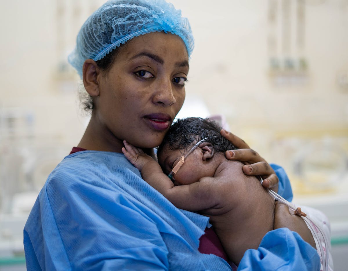 Health & Medicine- Twenty-year old Sarah Mohamed cuddles her 20-day old child Omnia in an isolated room at the Neonatal Intensive Care Unit (NICU) in Saad Abu Alela hospital located in the outskirts of Khartoum. Omnia was born with respiratory distress and a blocked nostril.