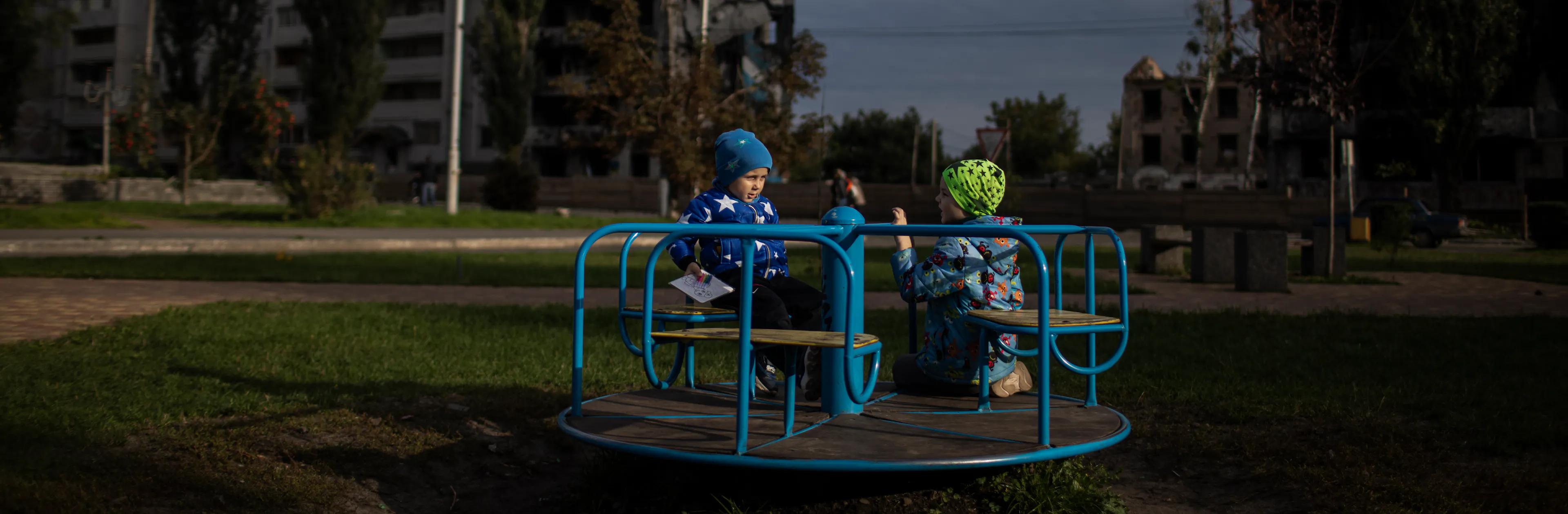 Children play against backdrop of destroyed buildings - Ukraine