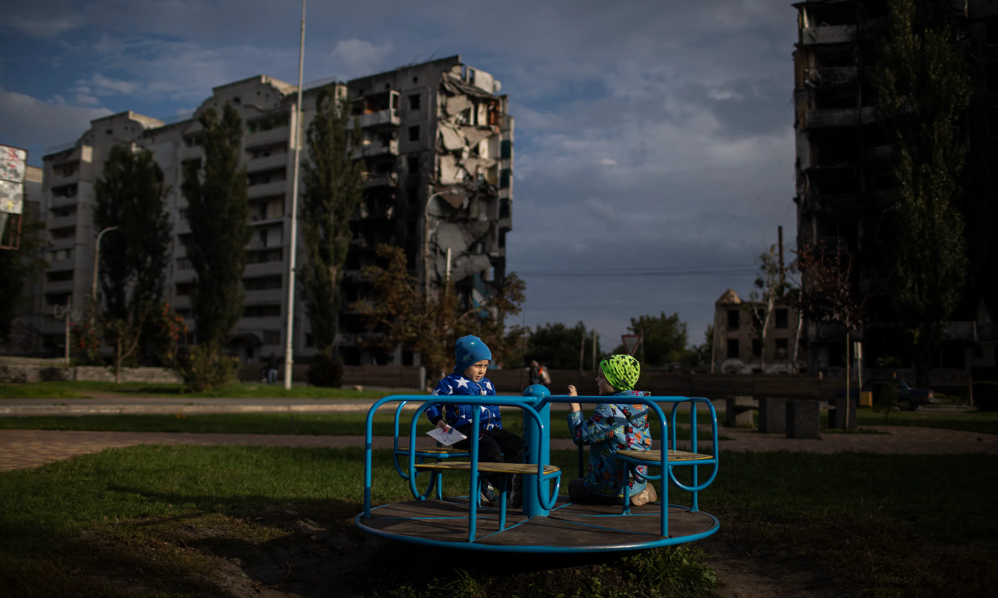 Children play against backdrop of destroyed buildings - Ukraine