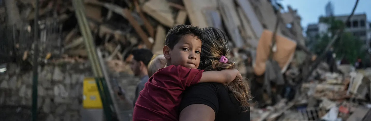 People walk past a collapsed building following an earthquake in Caracas on June 25, 2026.