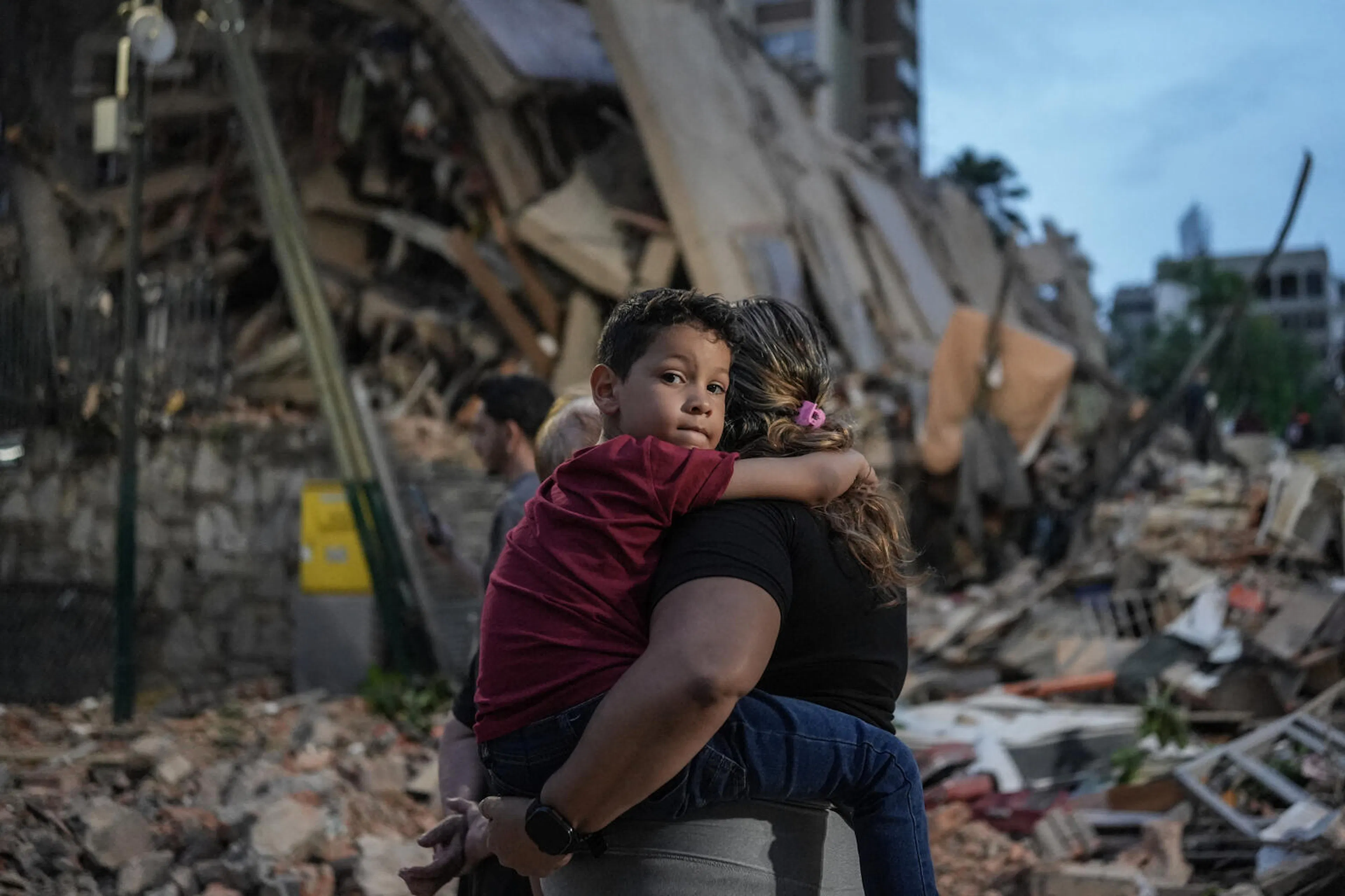 People walk past a collapsed building following an earthquake in Caracas on June 25, 2026.