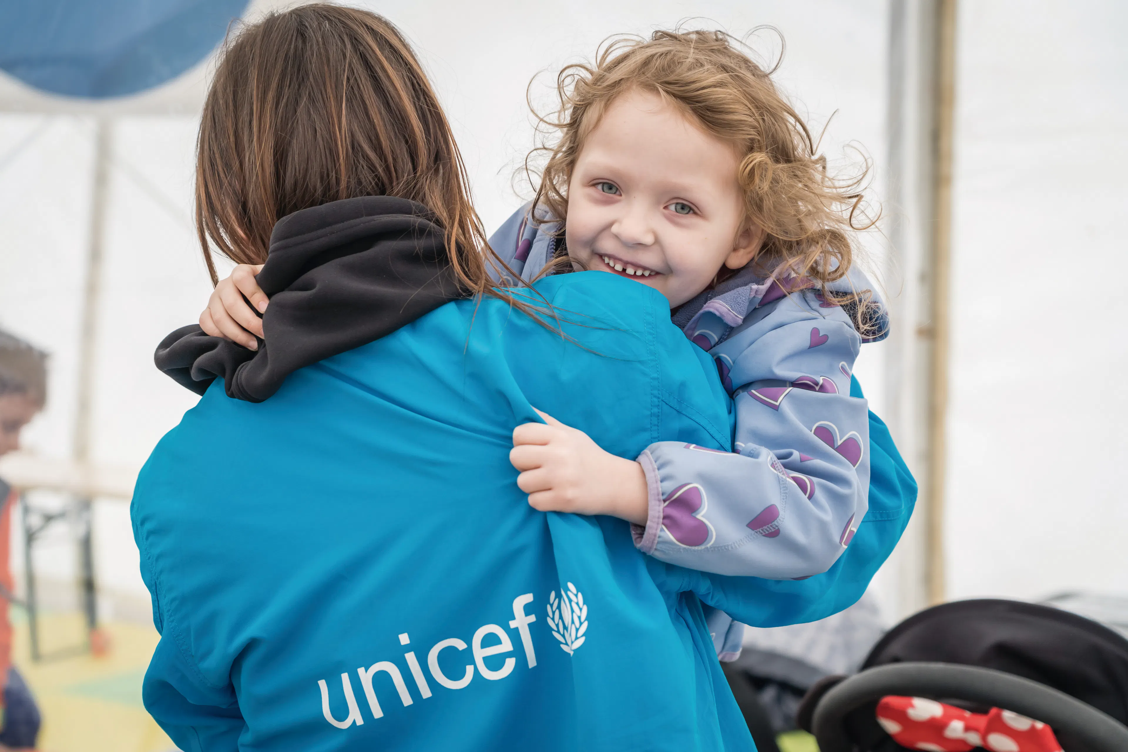 On 7 April 2022 at a Blue Dot hub in Isaccea border crossing, Romania, 5-year-old Emma plays with a UNICEF staff member.