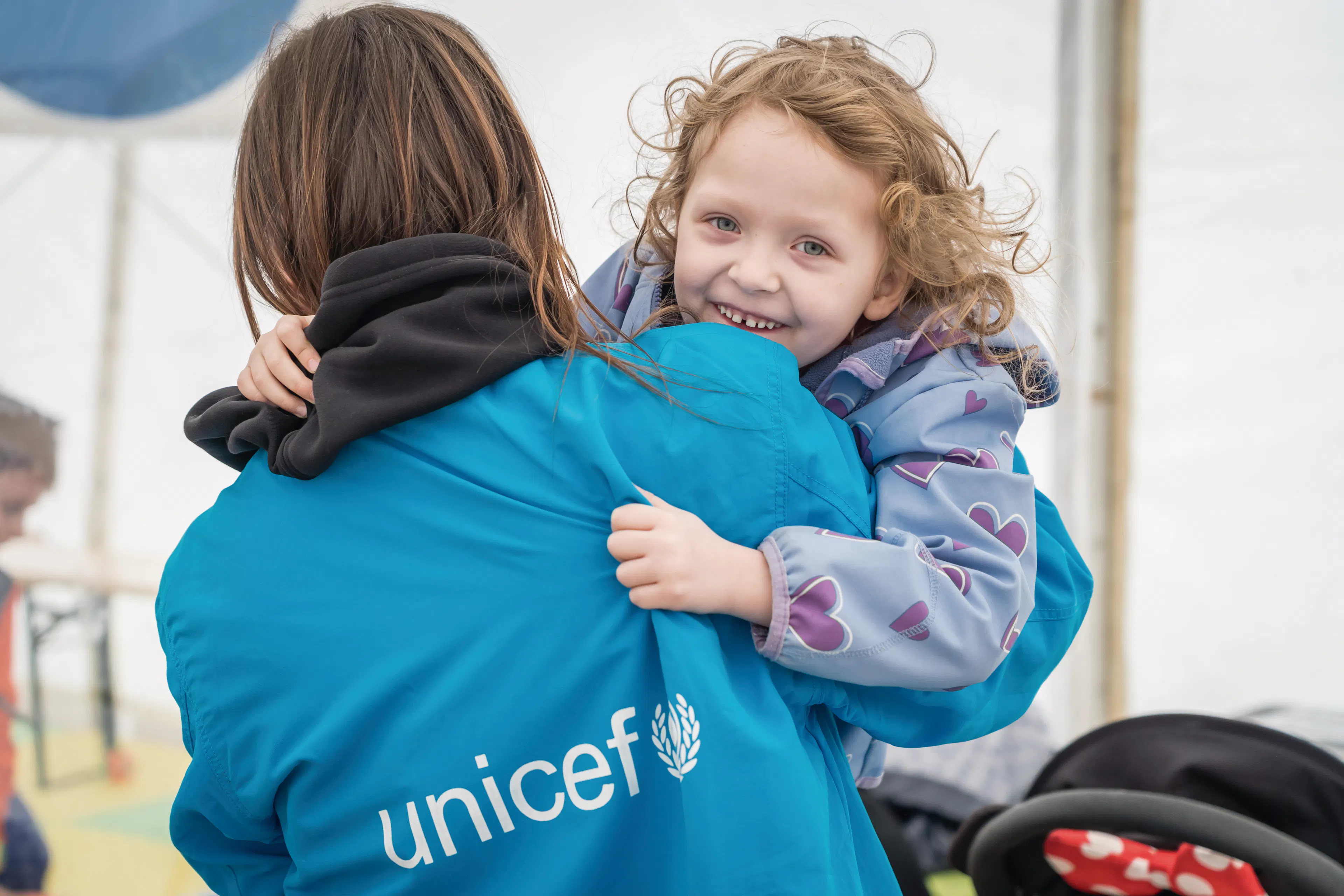 On 7 April 2022 at a Blue Dot hub in Isaccea border crossing, Romania, 5-year-old Emma plays with a UNICEF staff member.