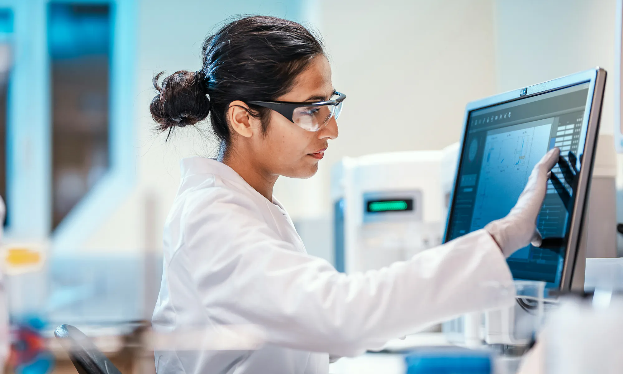 A lab technician using a touch-screen computer