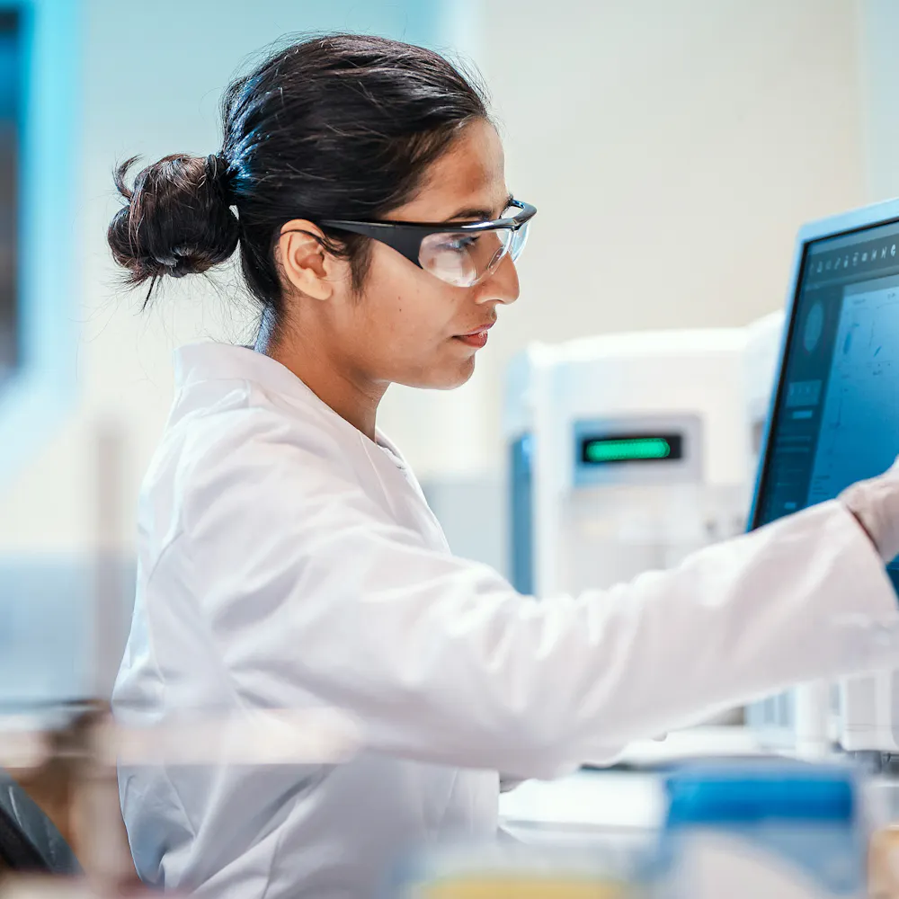 A lab technician using a touch-screen computer