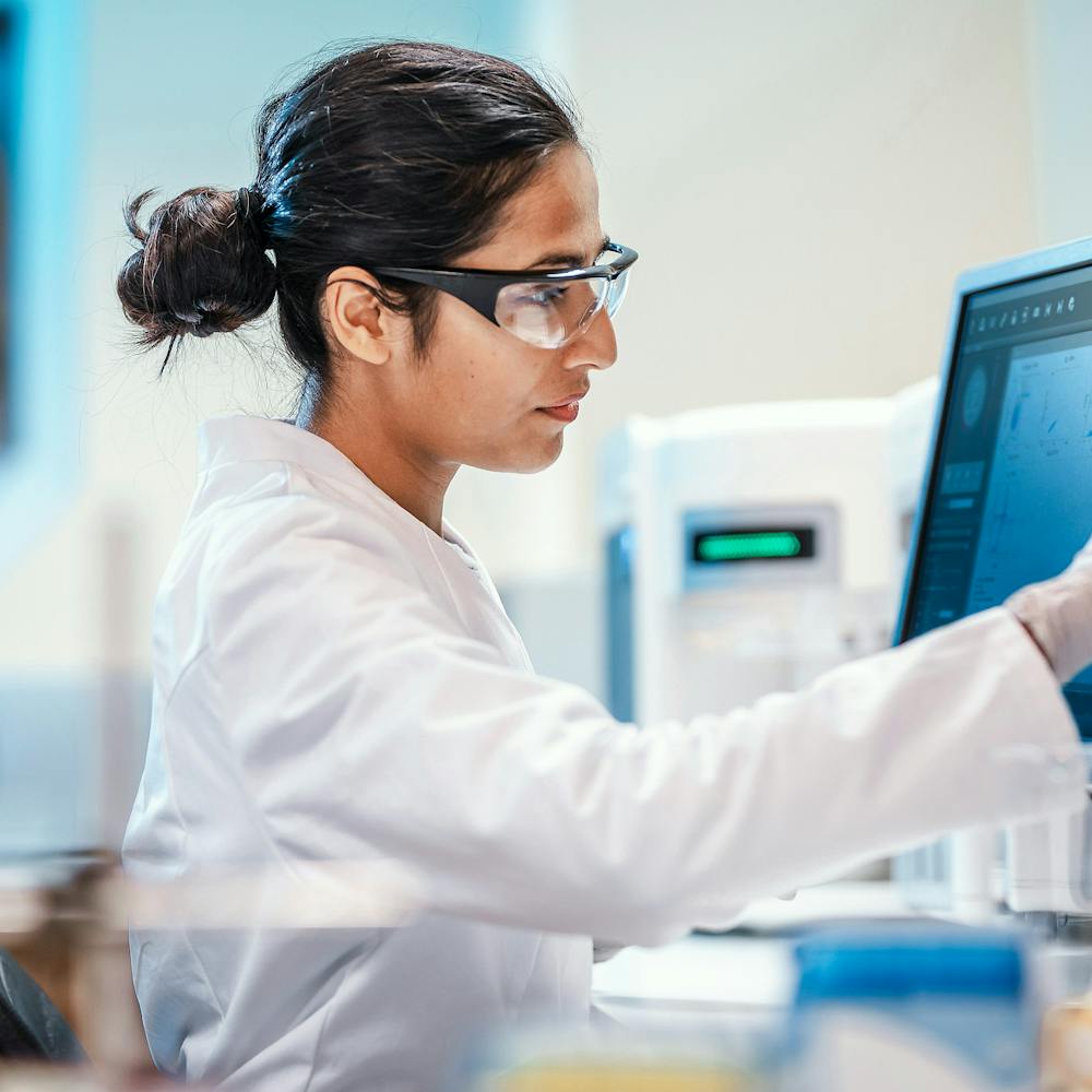A lab technician using a touch-screen computer