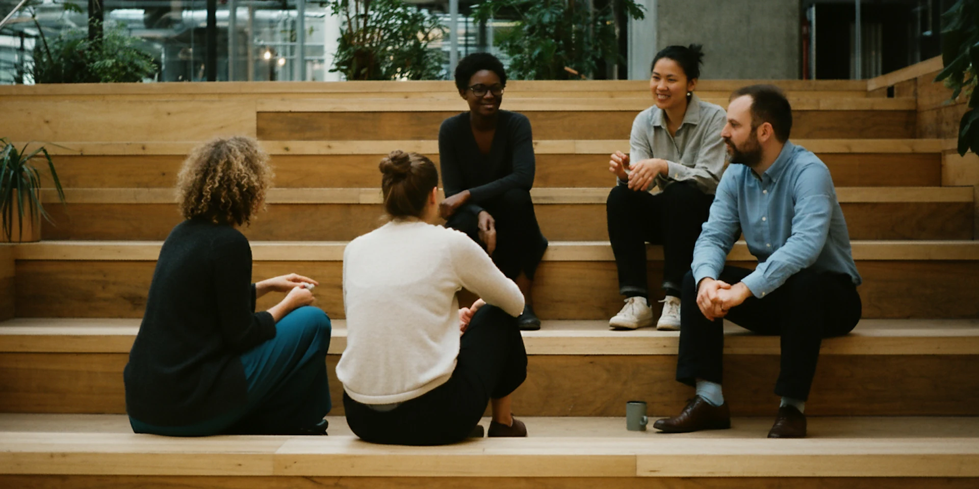 A group of diverse employees in a casual meeting, brainstorming solutions to individual and role-level stressors in a relaxed atmosphere.