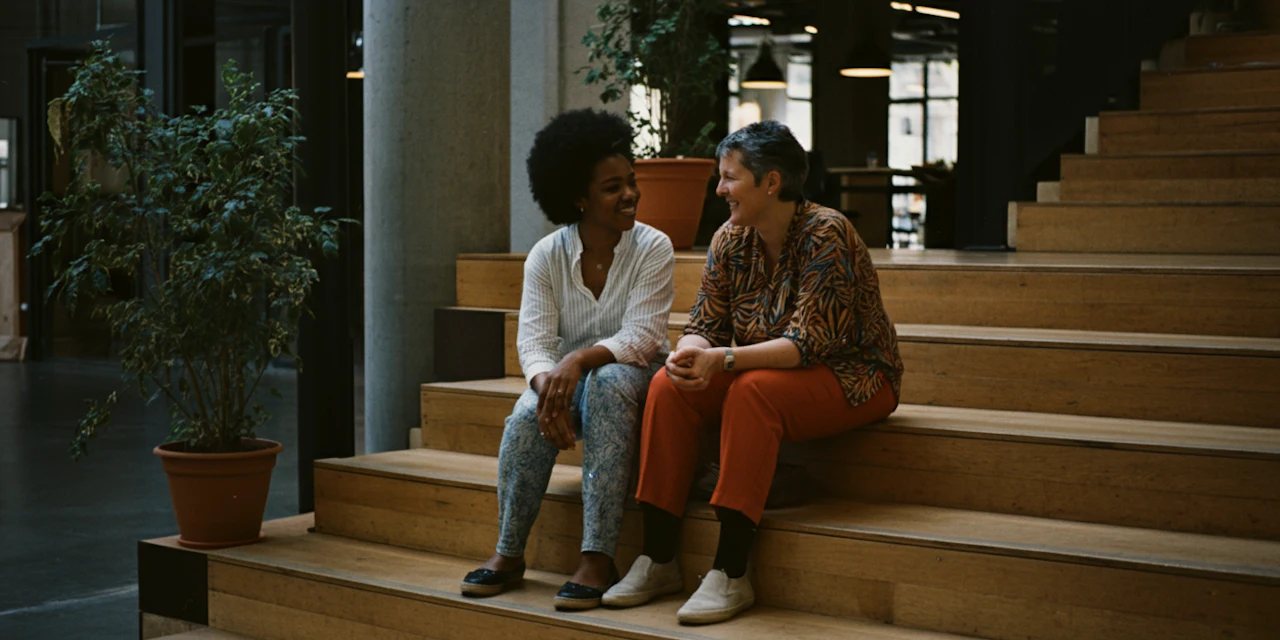 A modern office setting with relaxed employees discussing wellness programs, symbolizing the impact of workplace wellness on employee retention.