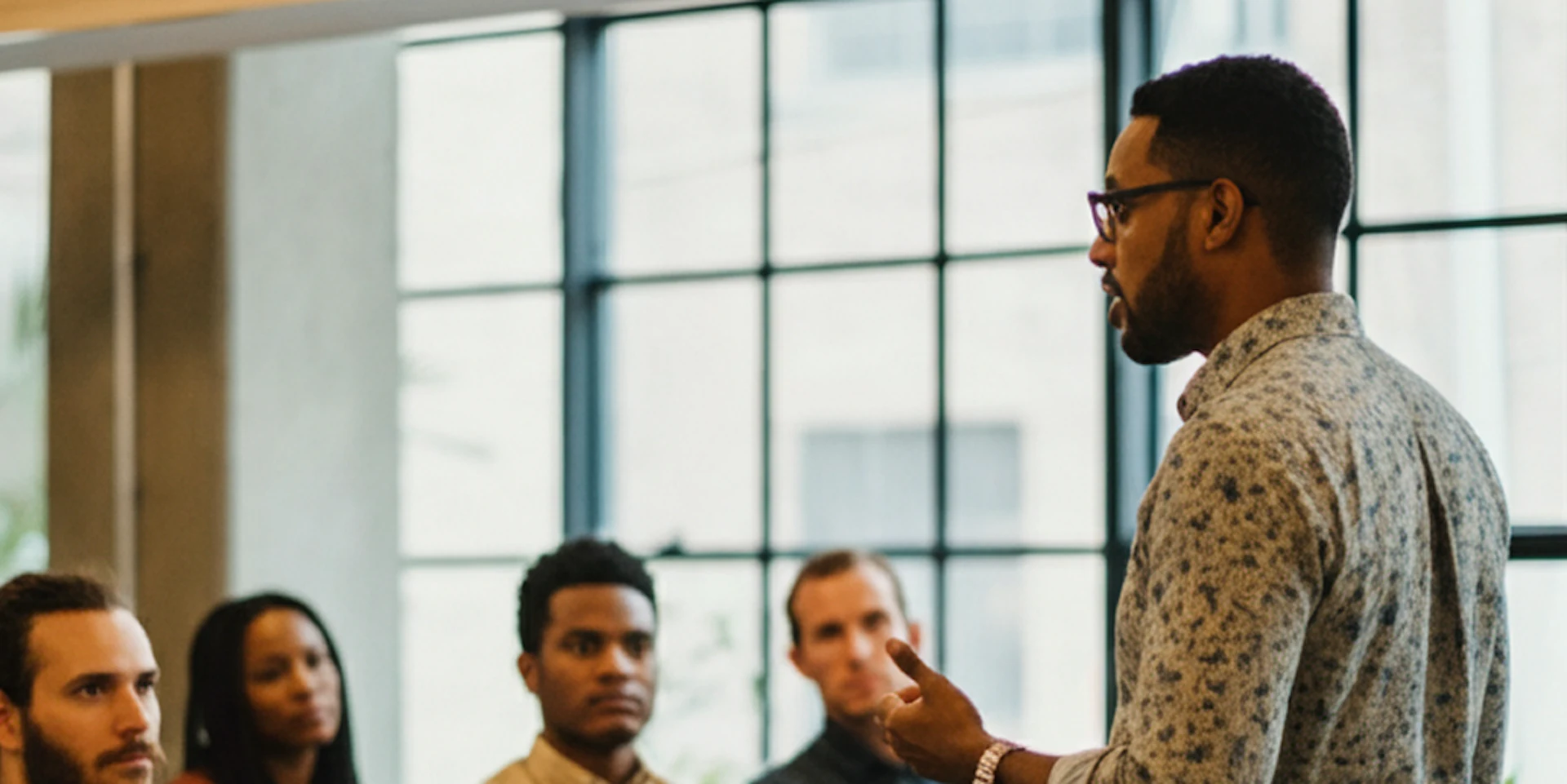 A presentation in a modern office with a diverse group engaged in learning about integrated mental health platforms.
