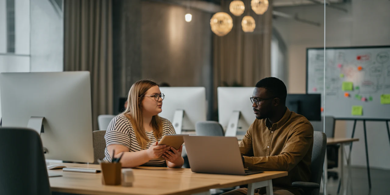 A diverse group of professionals engaged in a collaborative meeting discussing wellness initiatives in a modern office setting.