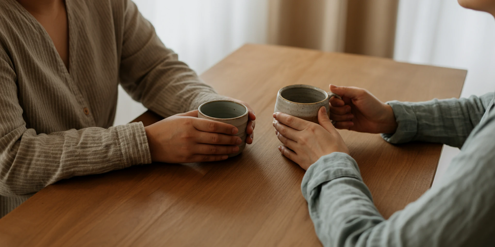 A cozy indoor scene with coffee cups on a wooden table, highlighting the importance of traditional therapy in mental health support.
