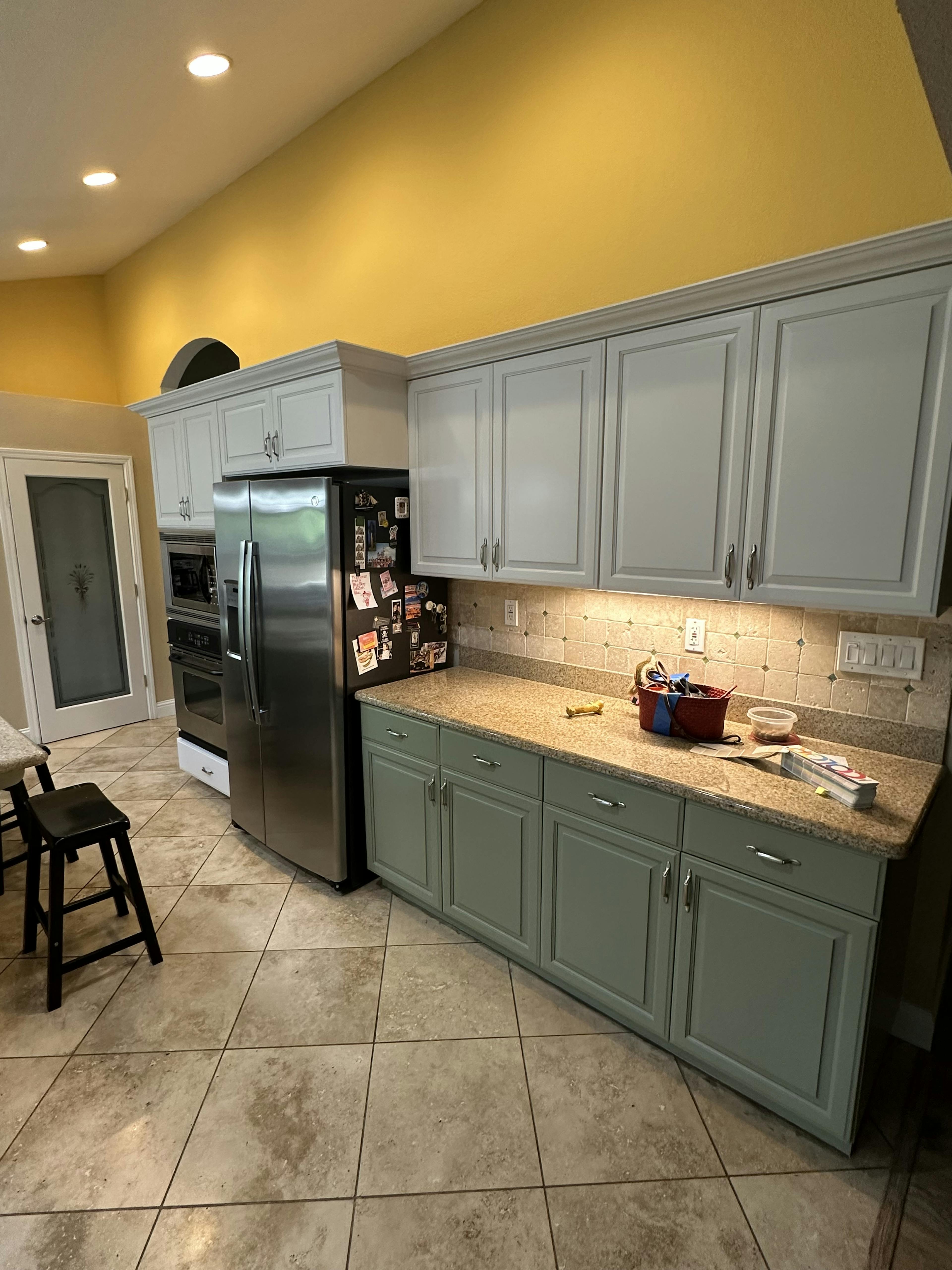 A kitchen with ambient lighting, two toned cabinets