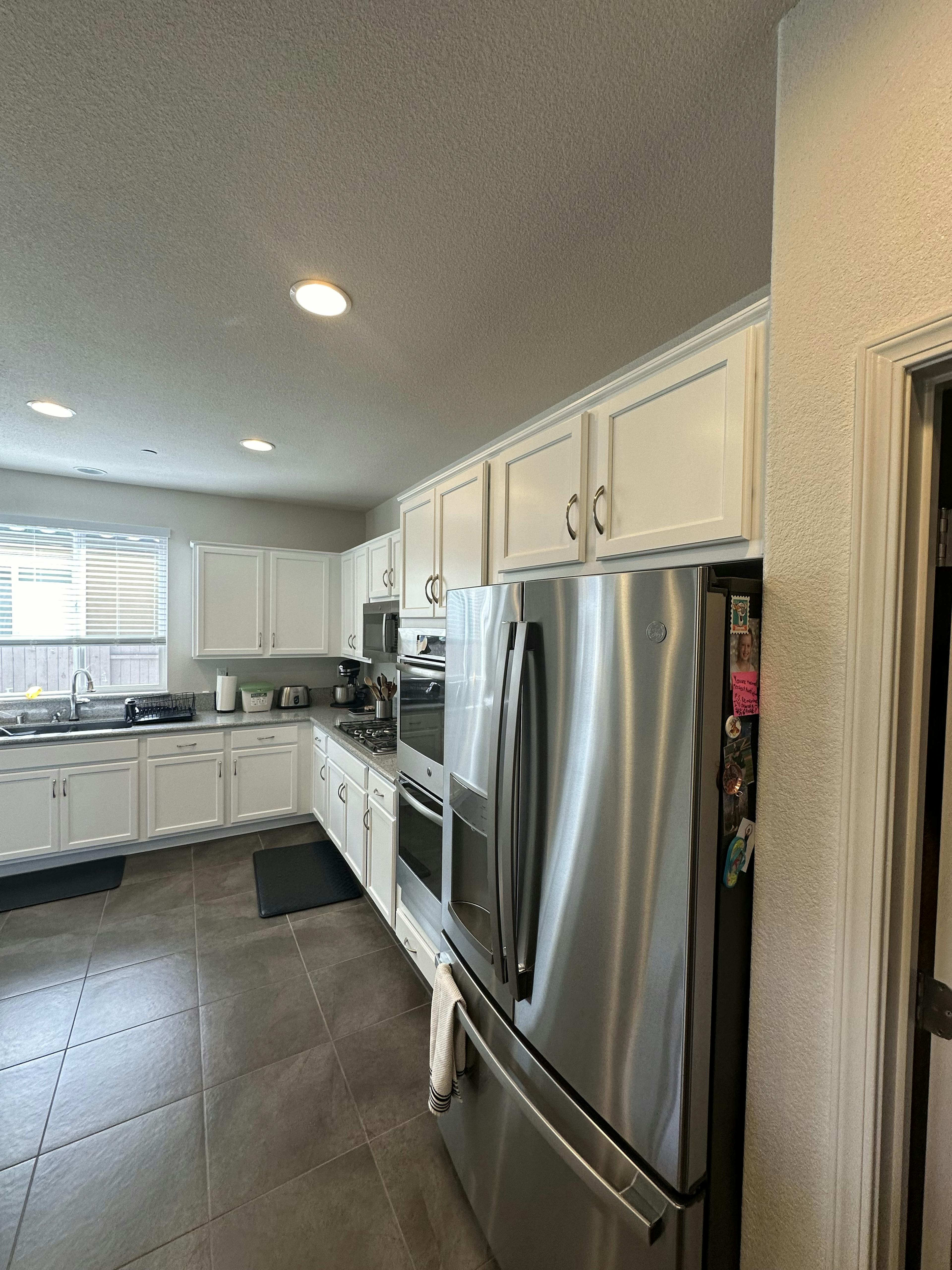 A close-up of the kitchen showing a stove and hood against a tiled backsplash.