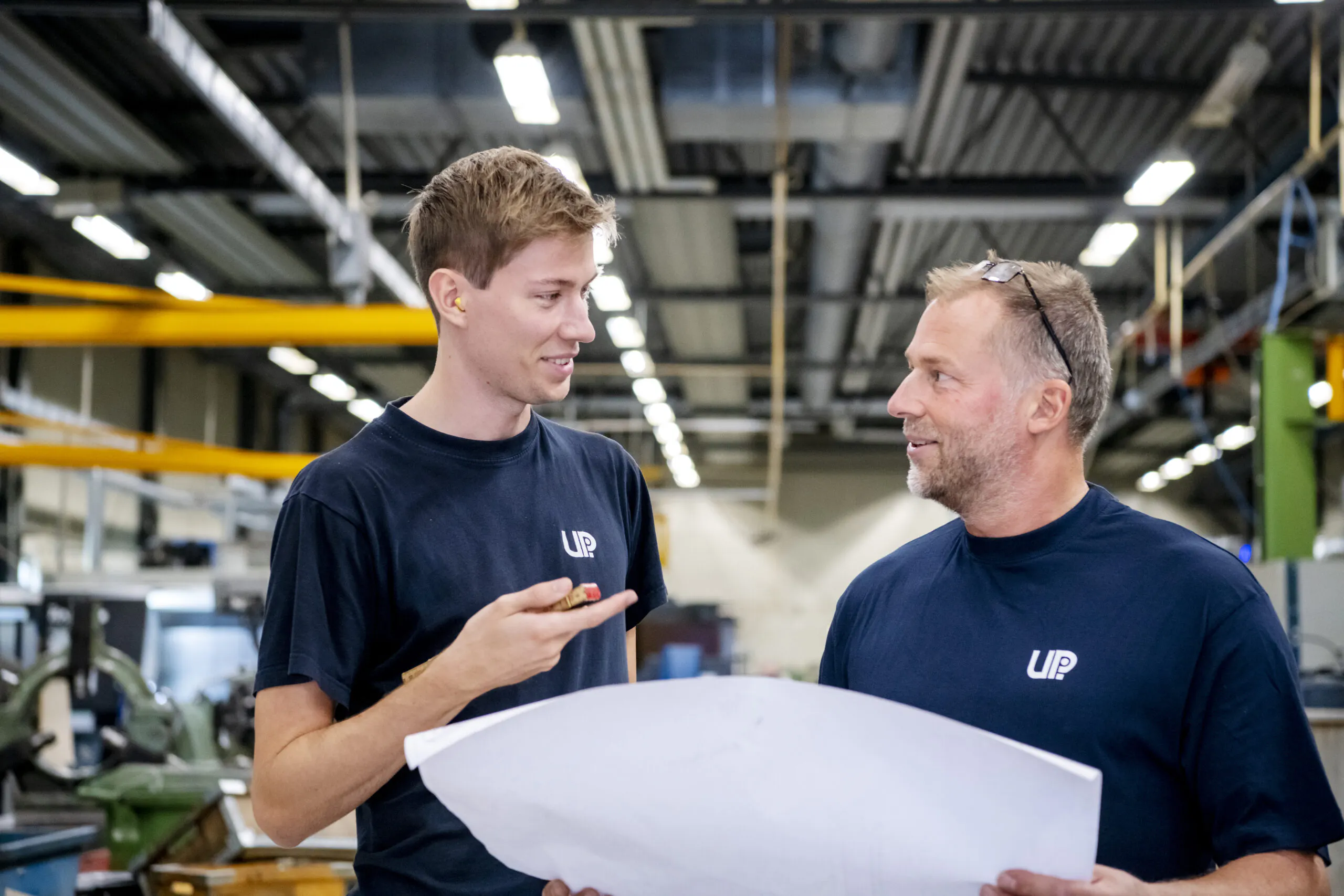 Två medarbetare diskuterar över en ritning på UPI