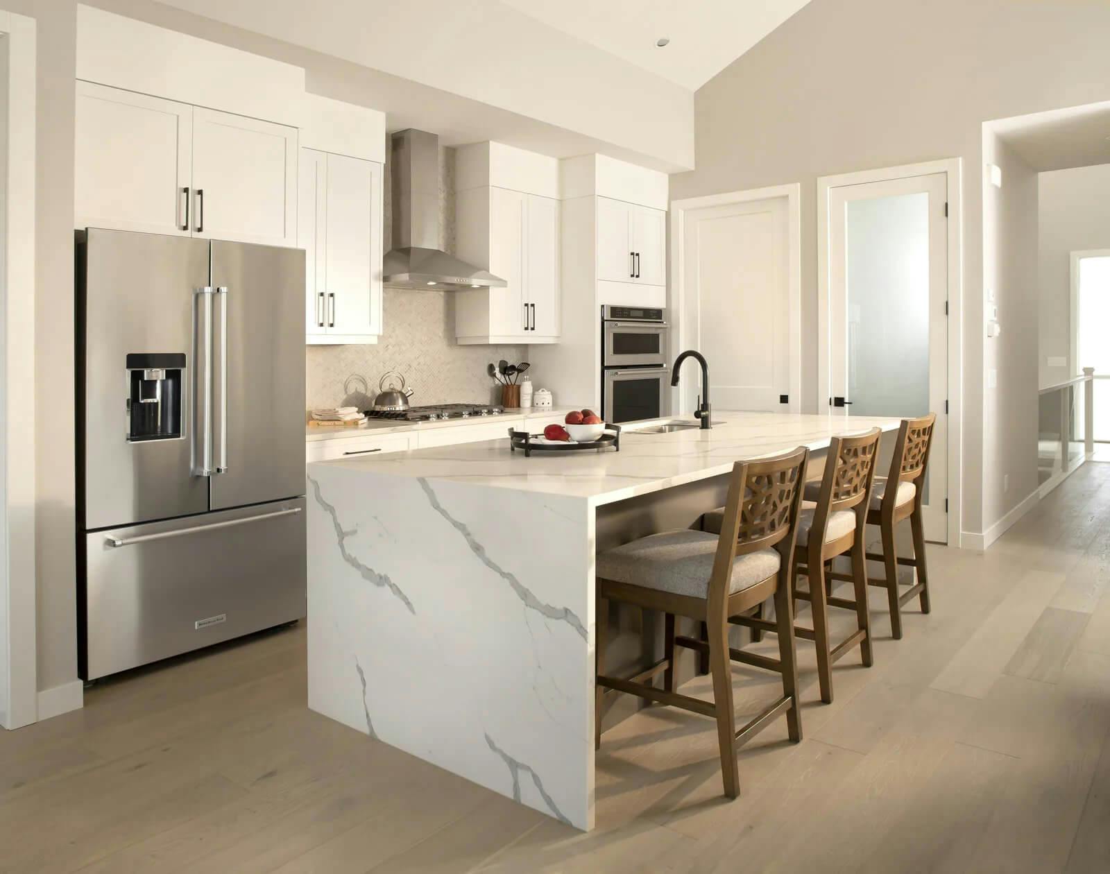 Marbled kitchen island with a stainless steel fridge