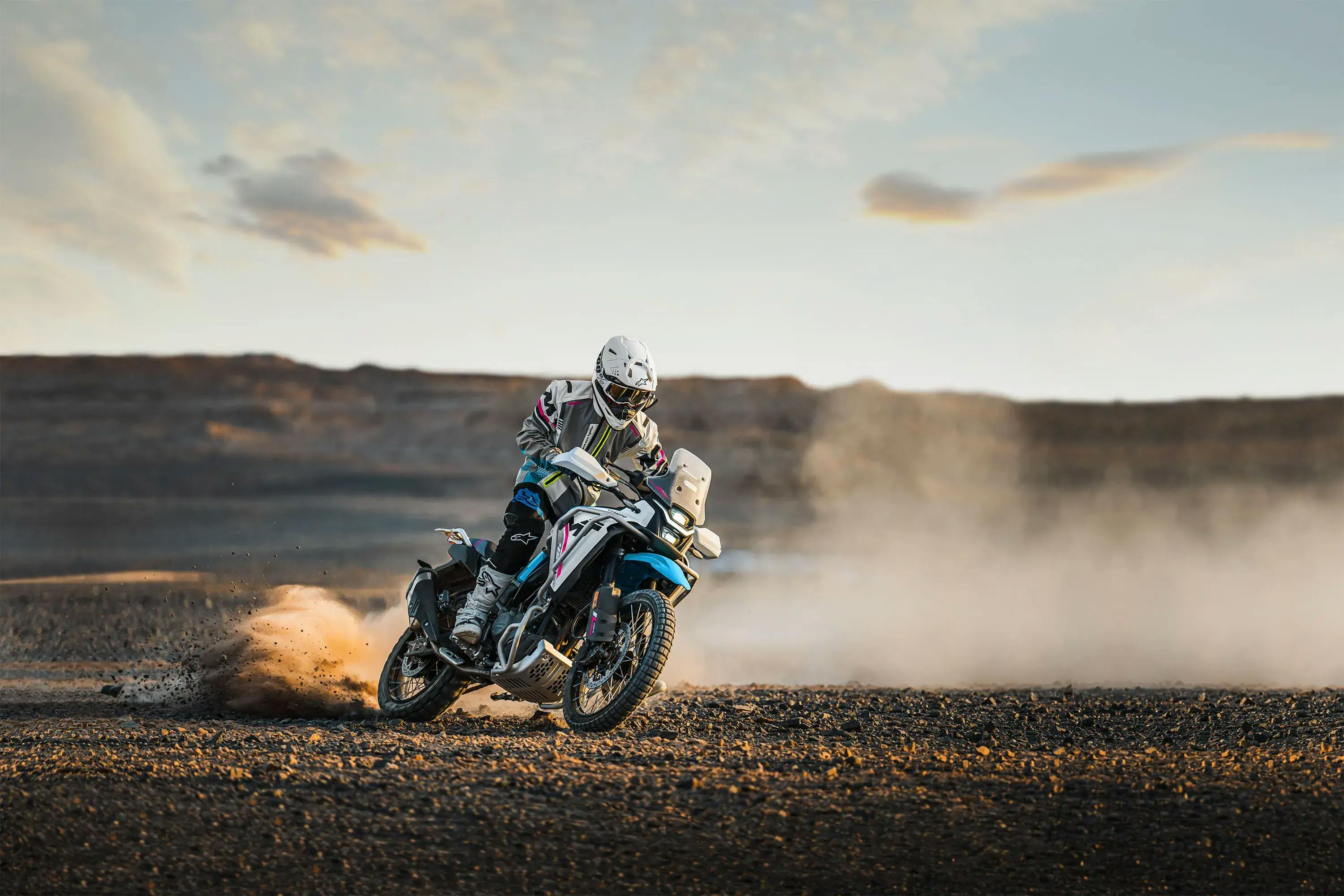Piloto con una CFMOTO conduciendo por terreno arenoso
