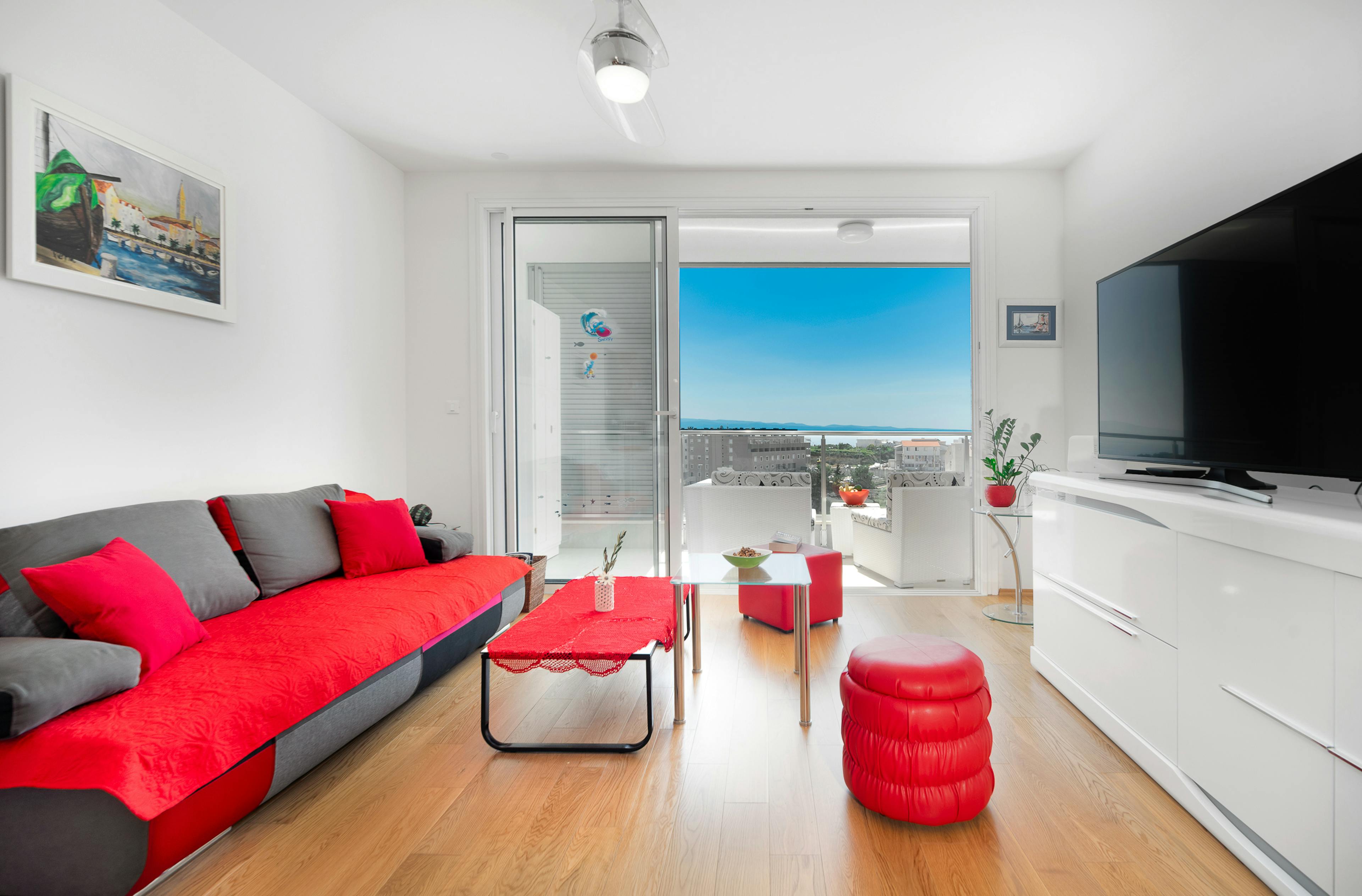 Living room with a pull out sofa, tv, balcony with sea view