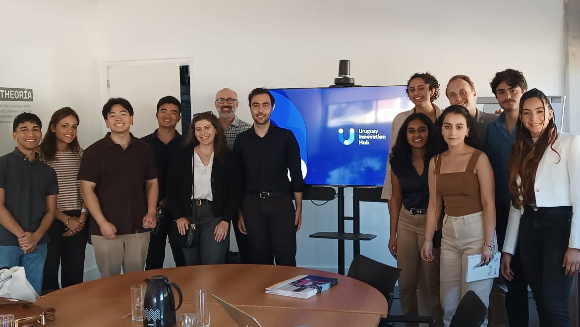 Estudiantes y profesores de la Universidad de Princeton en frente a una pantalla con el logo del Uruguay Innovation Hub