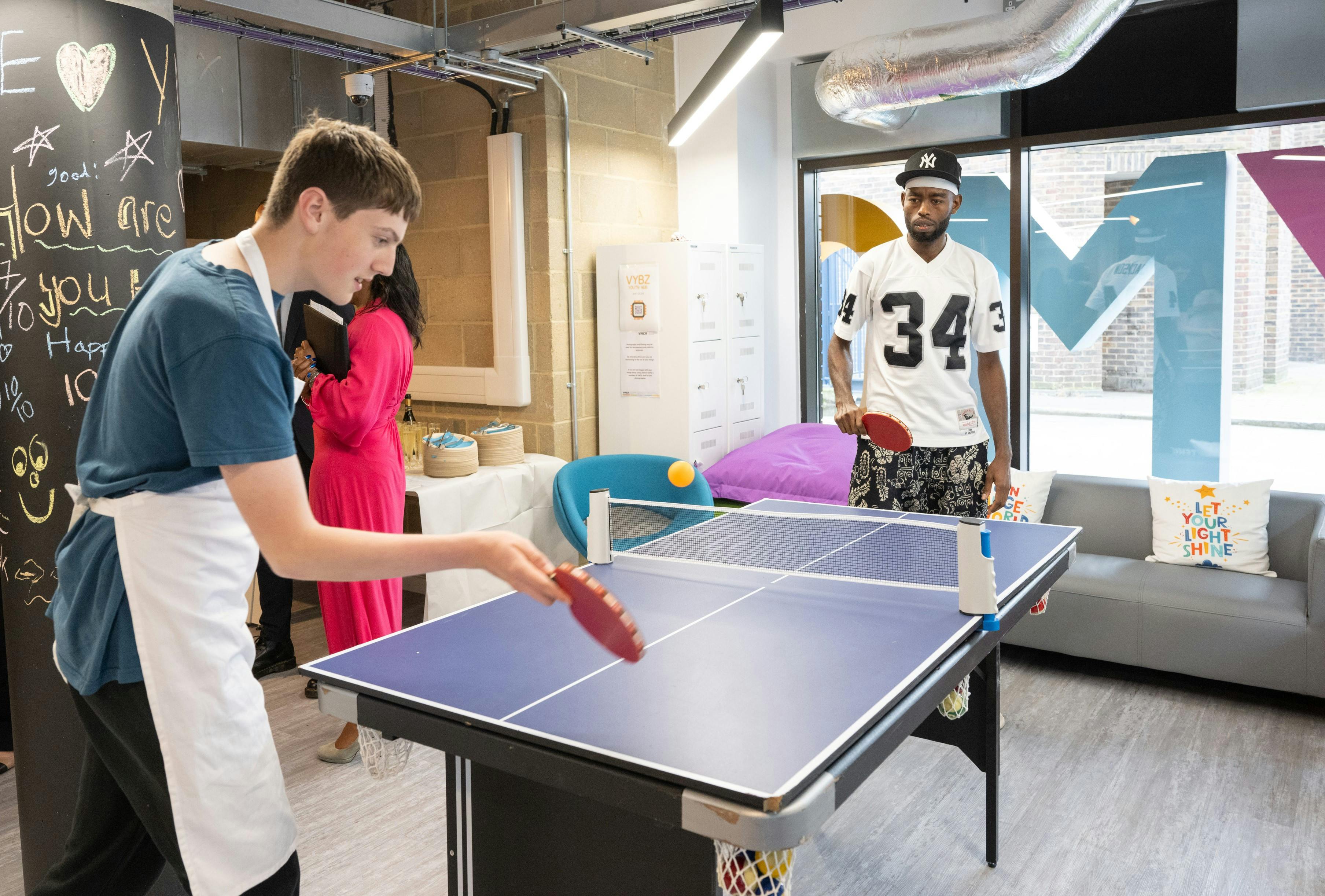 Two young people playing table tennis