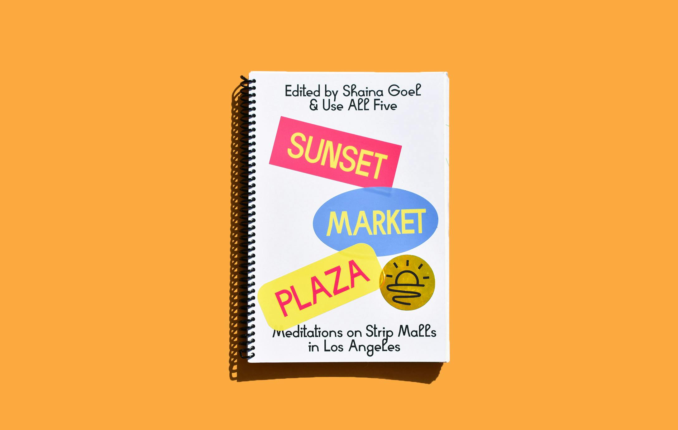A notebook with Sunset Maket Plaza stickers on it