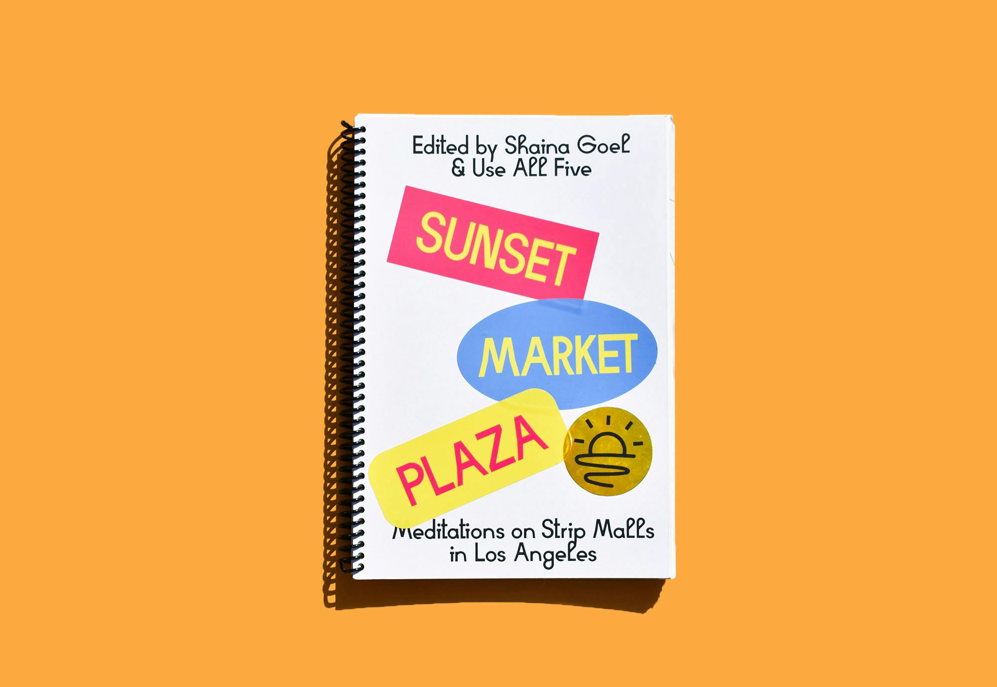 A notebook with Sunset Maket Plaza stickers on it