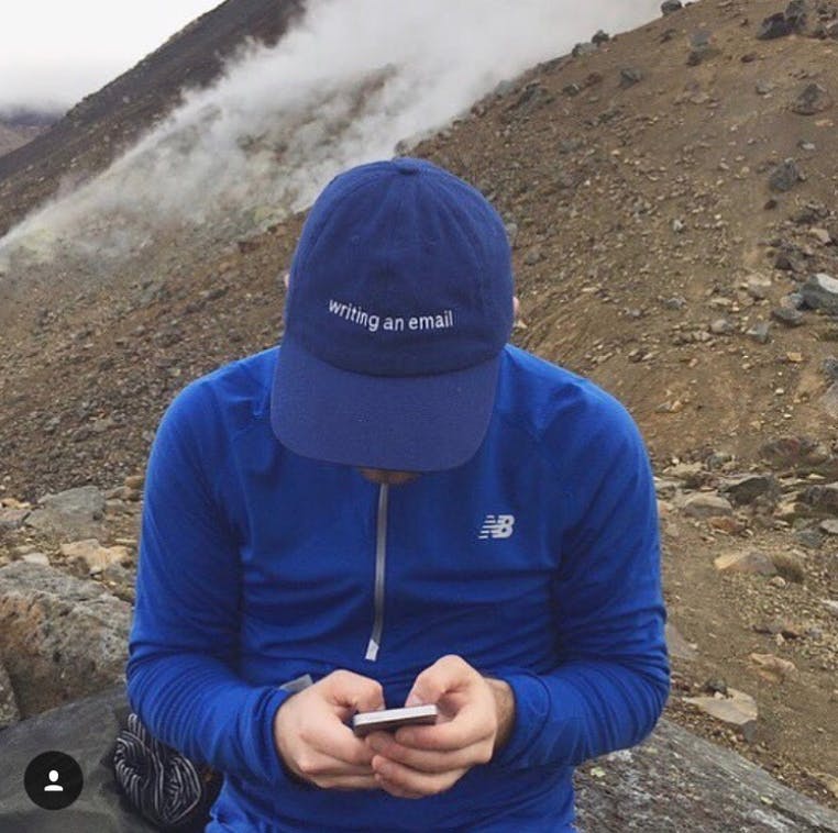 Person in blue wearing hat that says Writing an Email