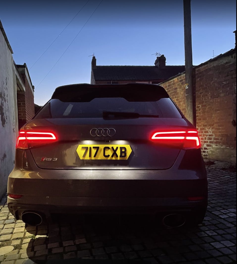 Audi RS3 rear at night with the taillights illuminated and our hex style rear number plate