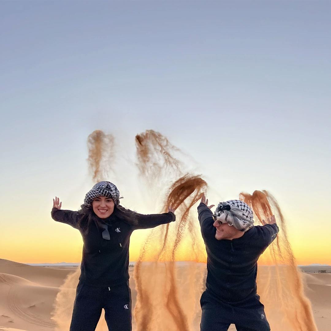 Due ragazzi lanciano la sabbia nel deserto