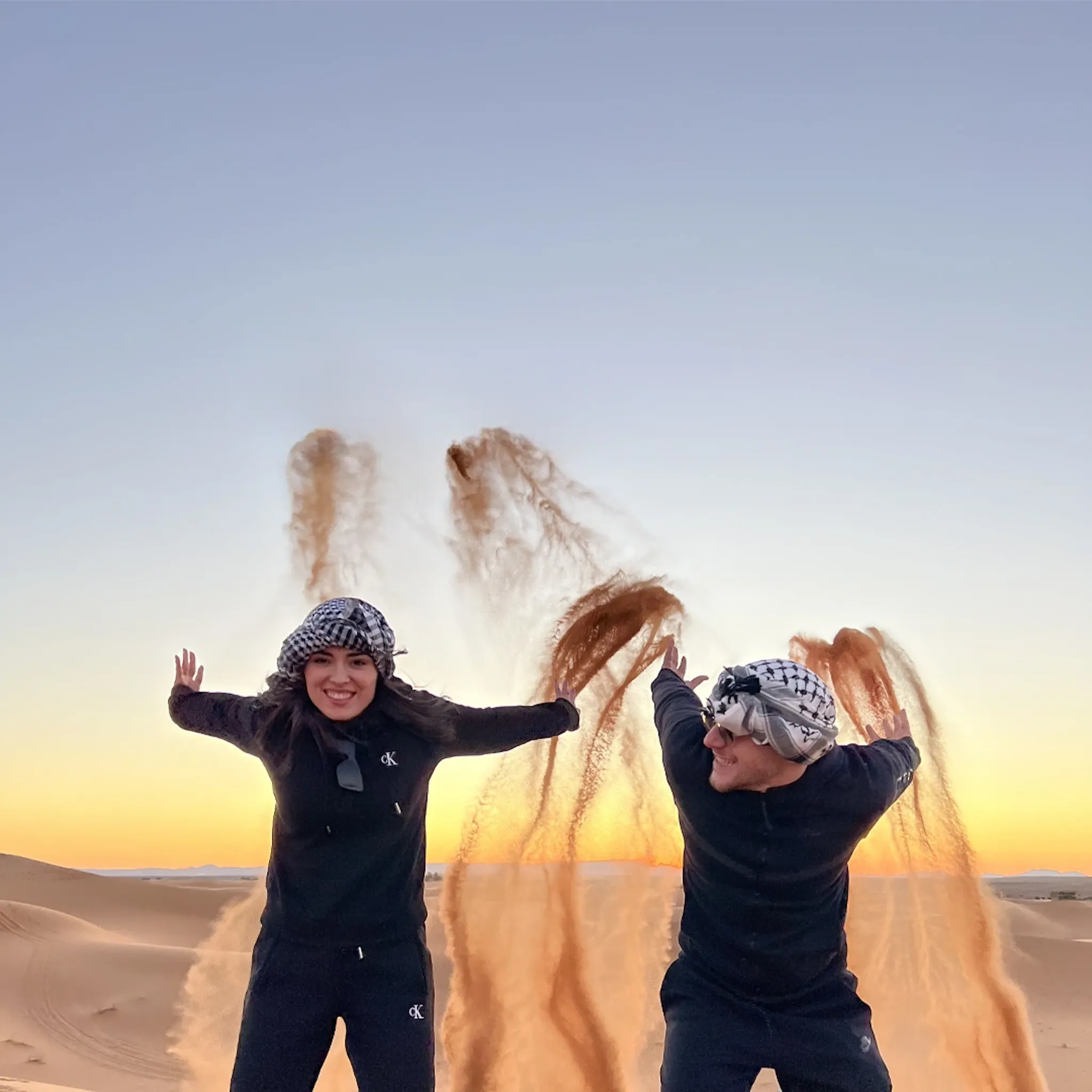 Due ragazzi lanciano la sabbia nel deserto