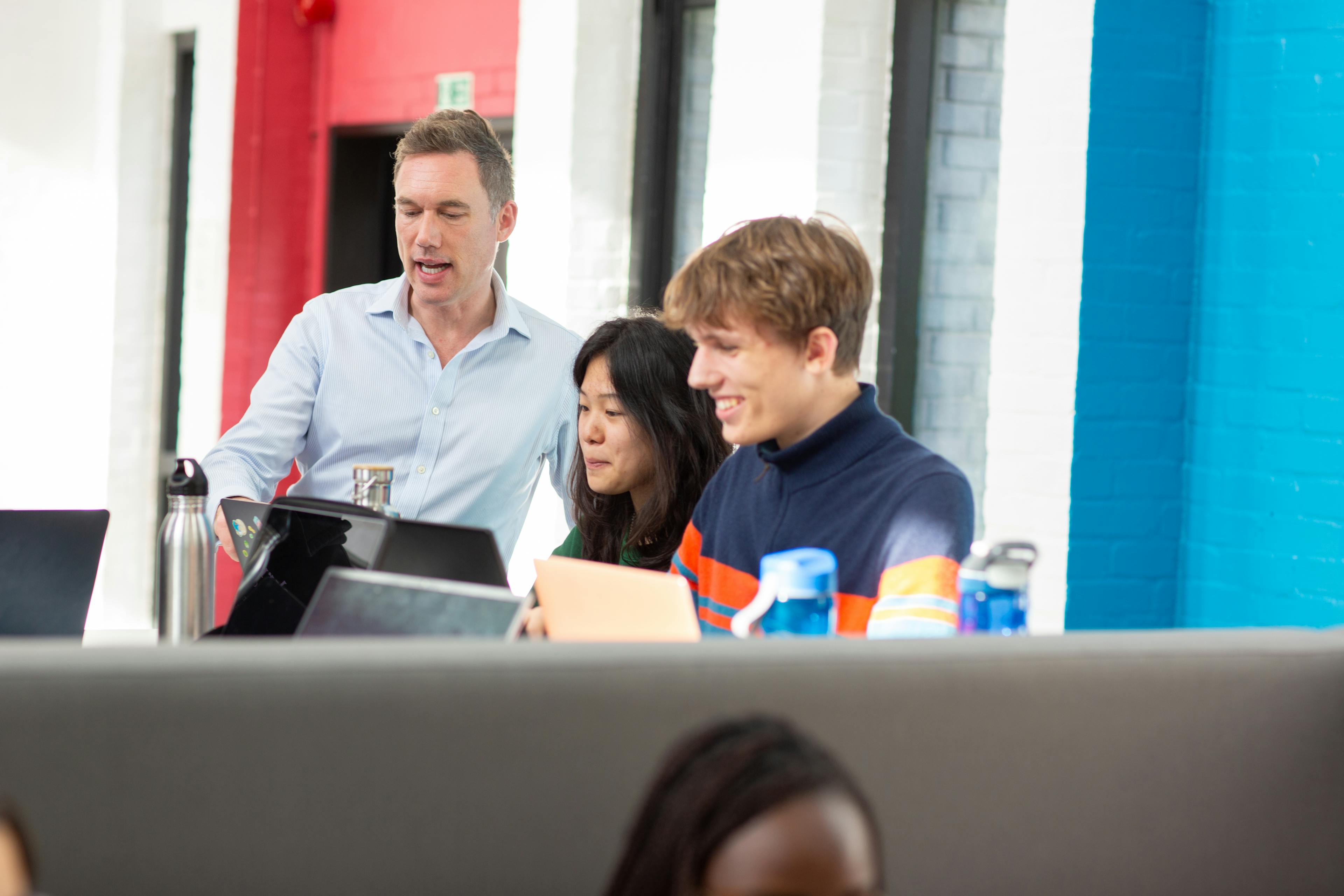 teacher with students at their laptops