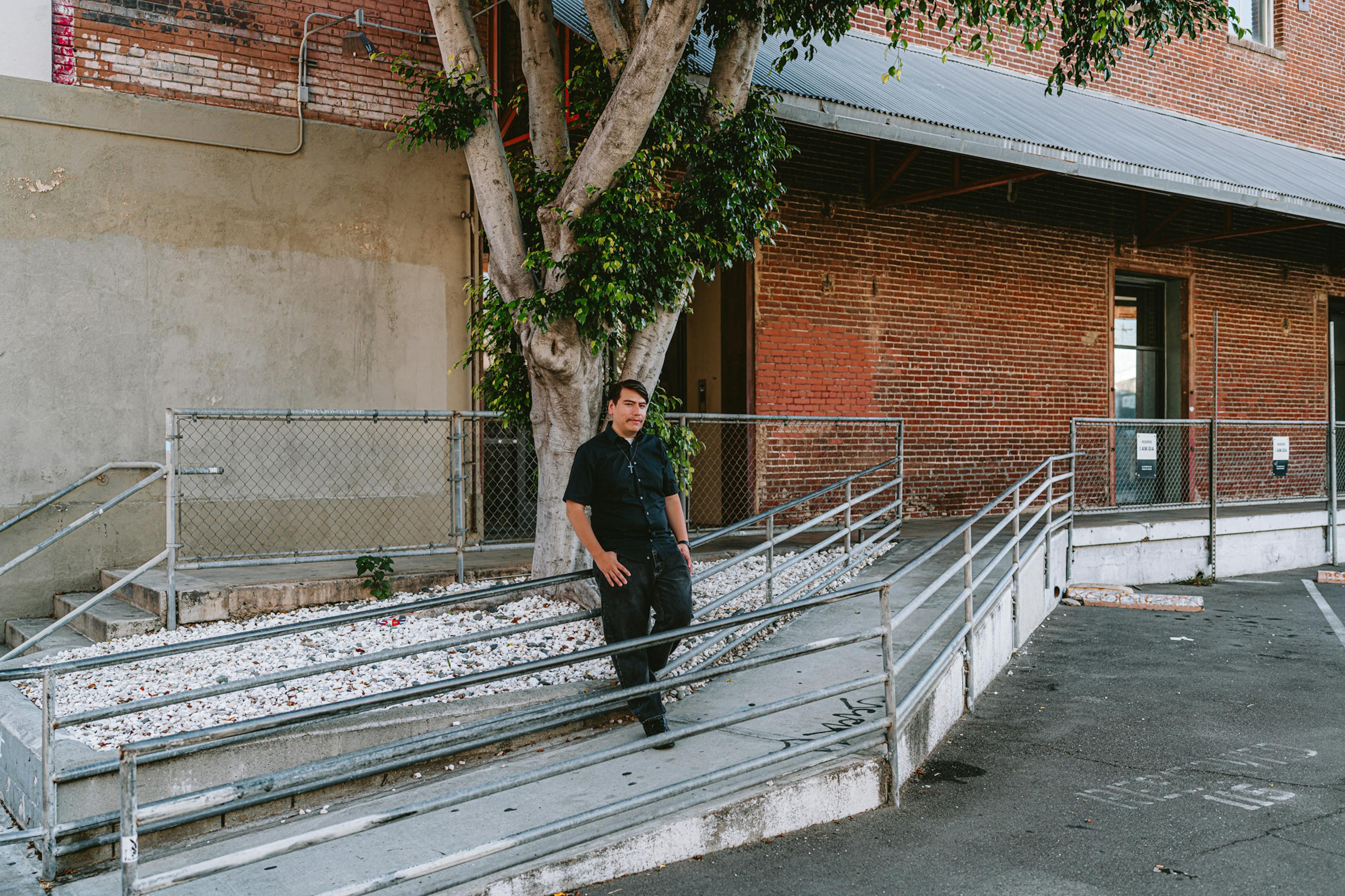 A man leaning on a railing in an urban landscape