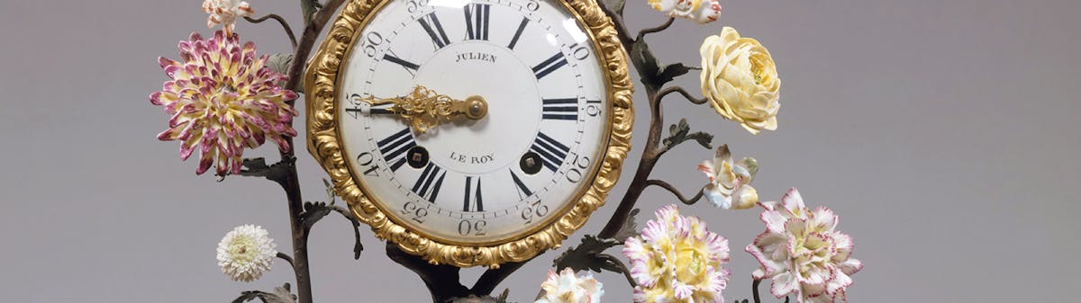 antique clock with floral sculpted surround