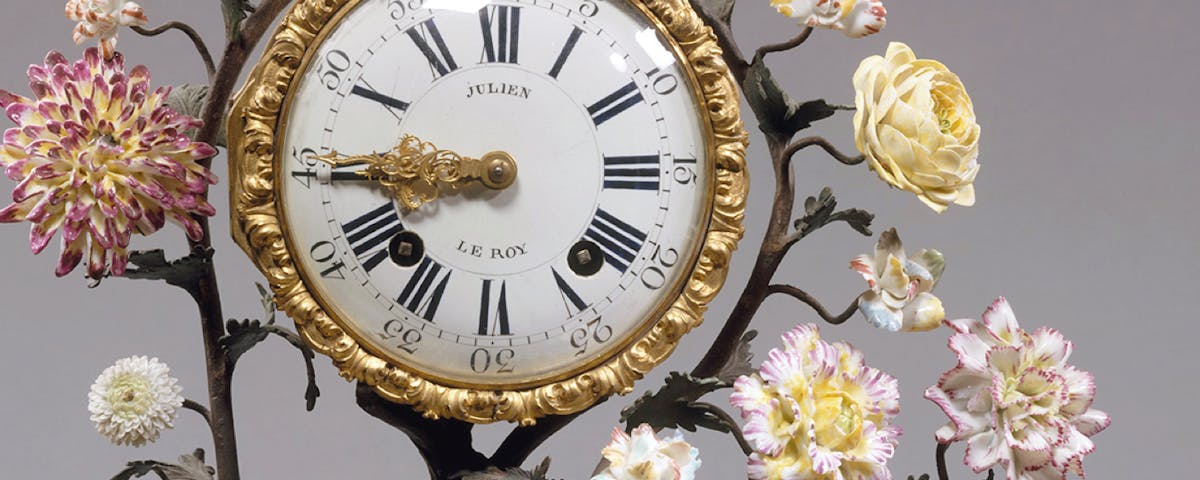 antique clock with floral sculpted surround