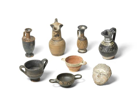 Seven miniature Greek pottery vessels and a Campanian terracotta gorgon mask. Circa 8th-4th Century B.C., 3cm – 12.3cm high