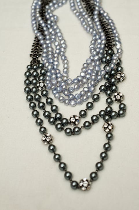 Zusammenstellung von Perlenketten, Ketten mit unechten Perlen und Colliers mit anthrazitfarbenen und klaren Steinen