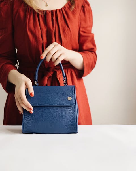 woman holding blue leather bag