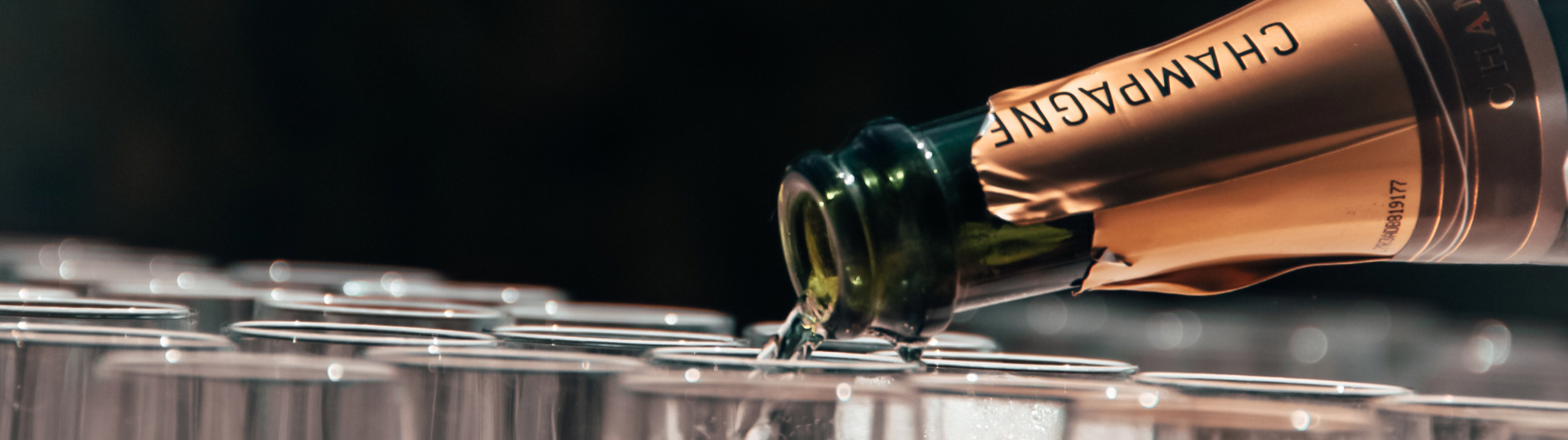 bottle of champagne filling champagne flutes