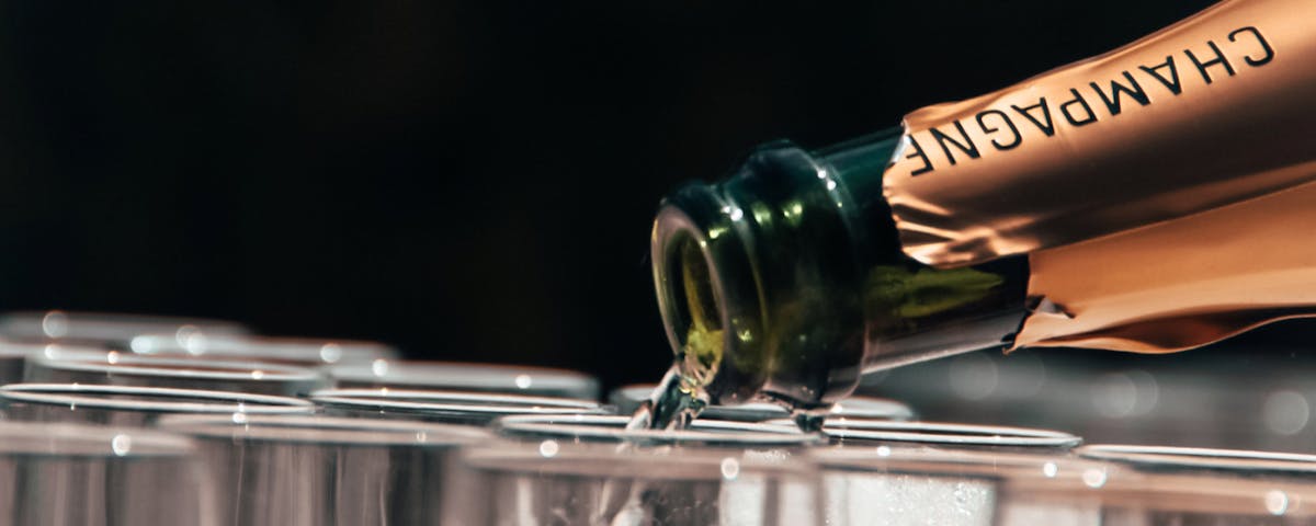 bottle of champagne filling champagne flutes