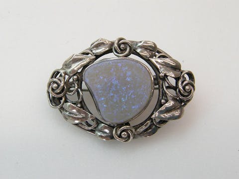 Oval brooch in sterling silver set with irregularly-shaped flat opal cabochon opal, 1920's.