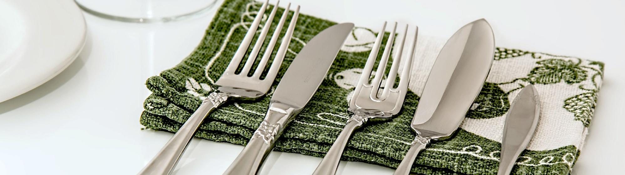 set of silver flatware on green printed napkin