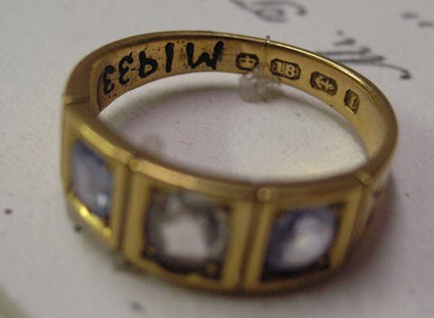 Hallmarks visible on a Victorian lady's ring in gold set with two blue and one clear stone (sapphire and diamond)