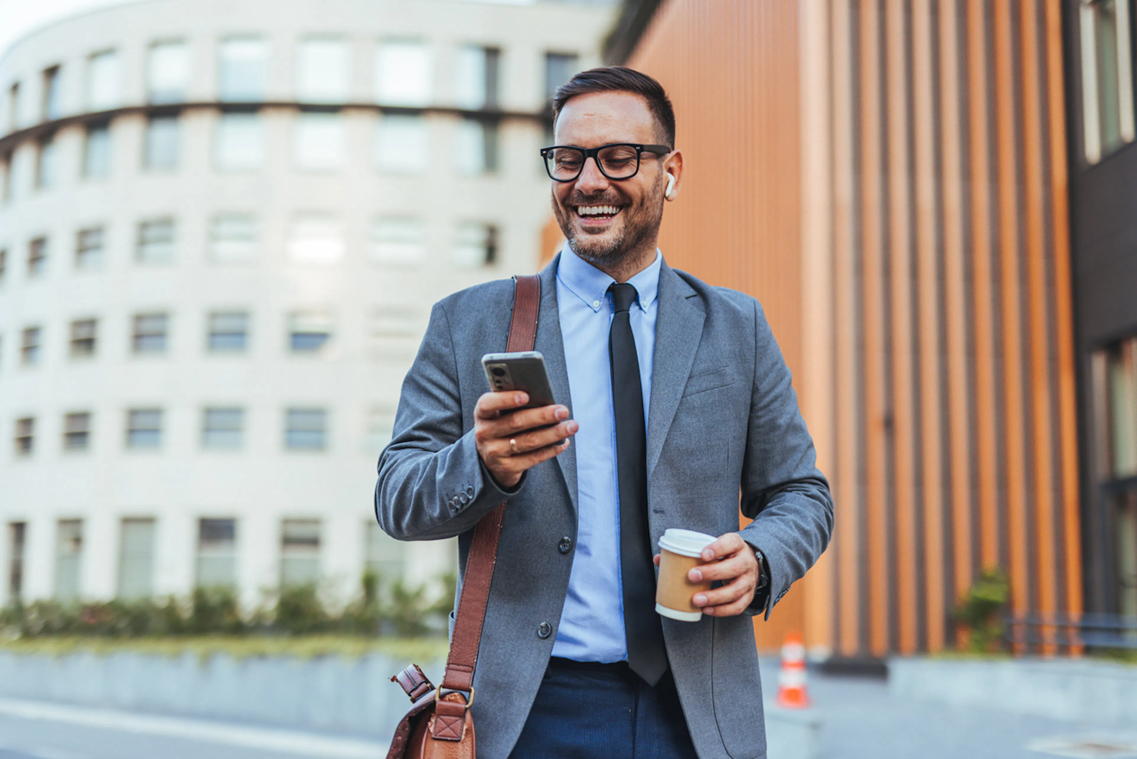 Businessman smiling while talking on the phone with earbuds