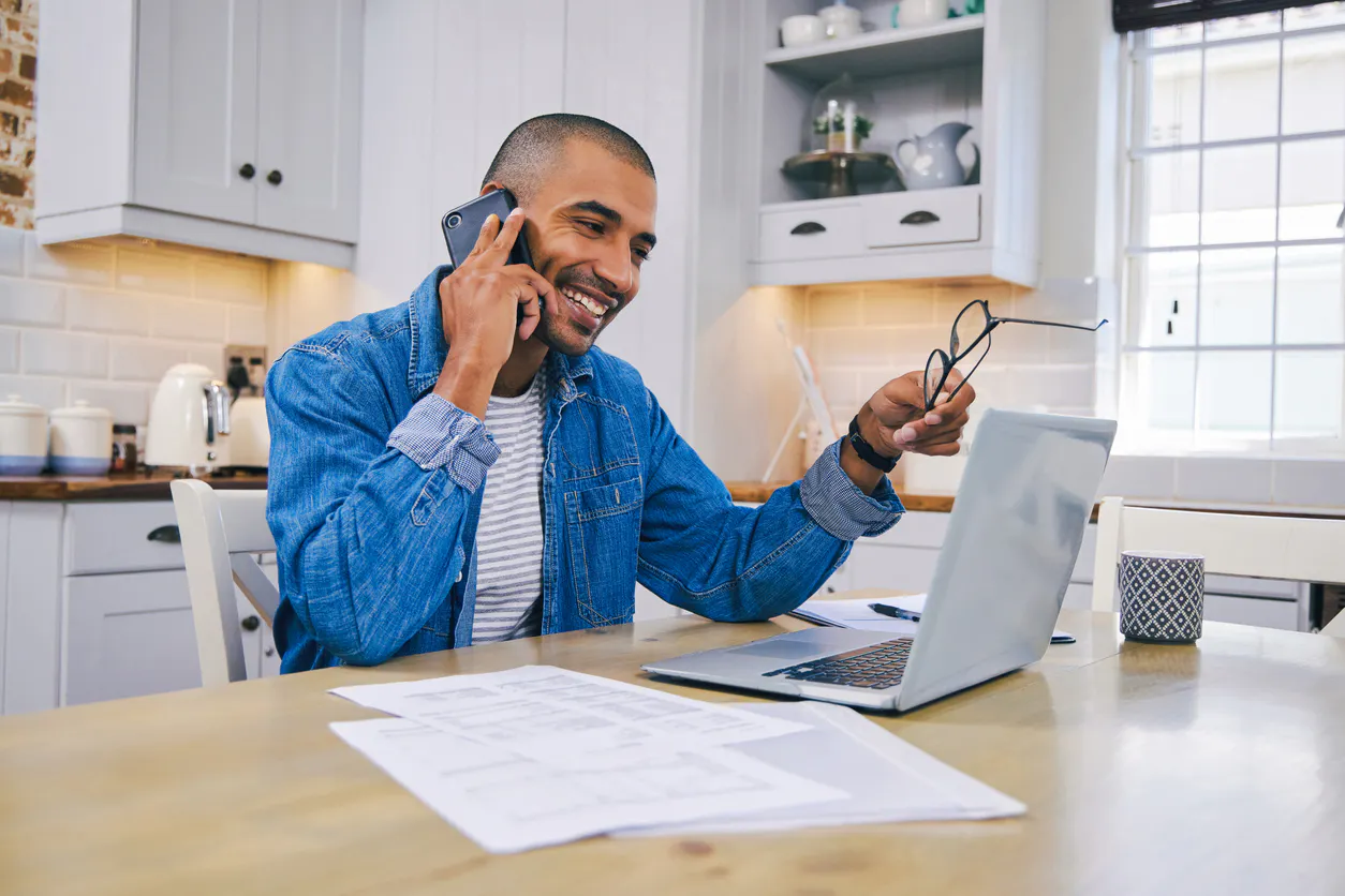 Smiling man in kitchen on the phone