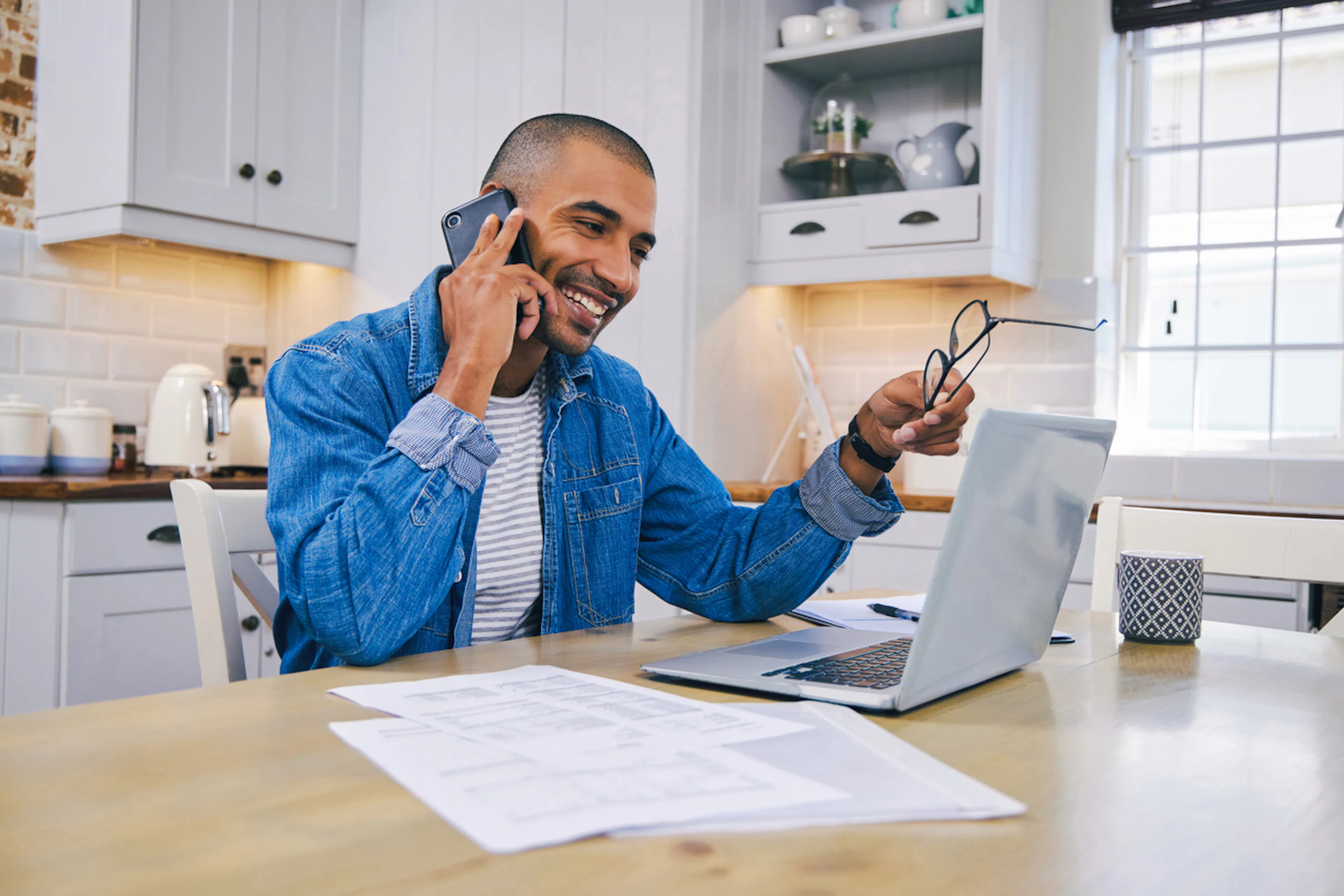 Smiling man in kitchen on the phone