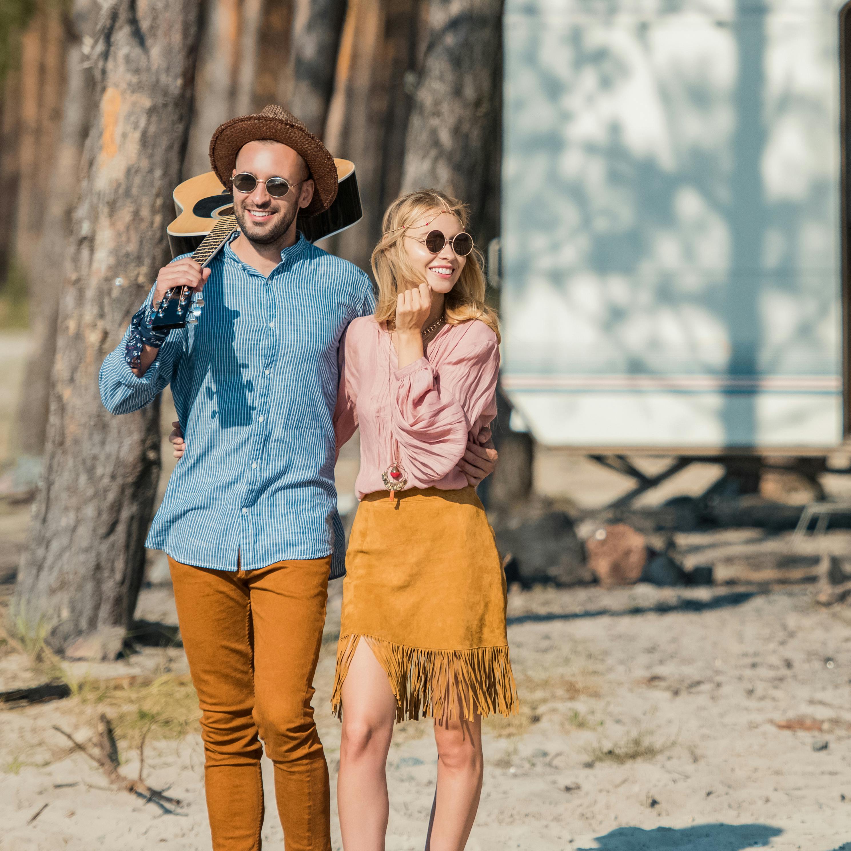 Young hippie couple hugging and standing with guit