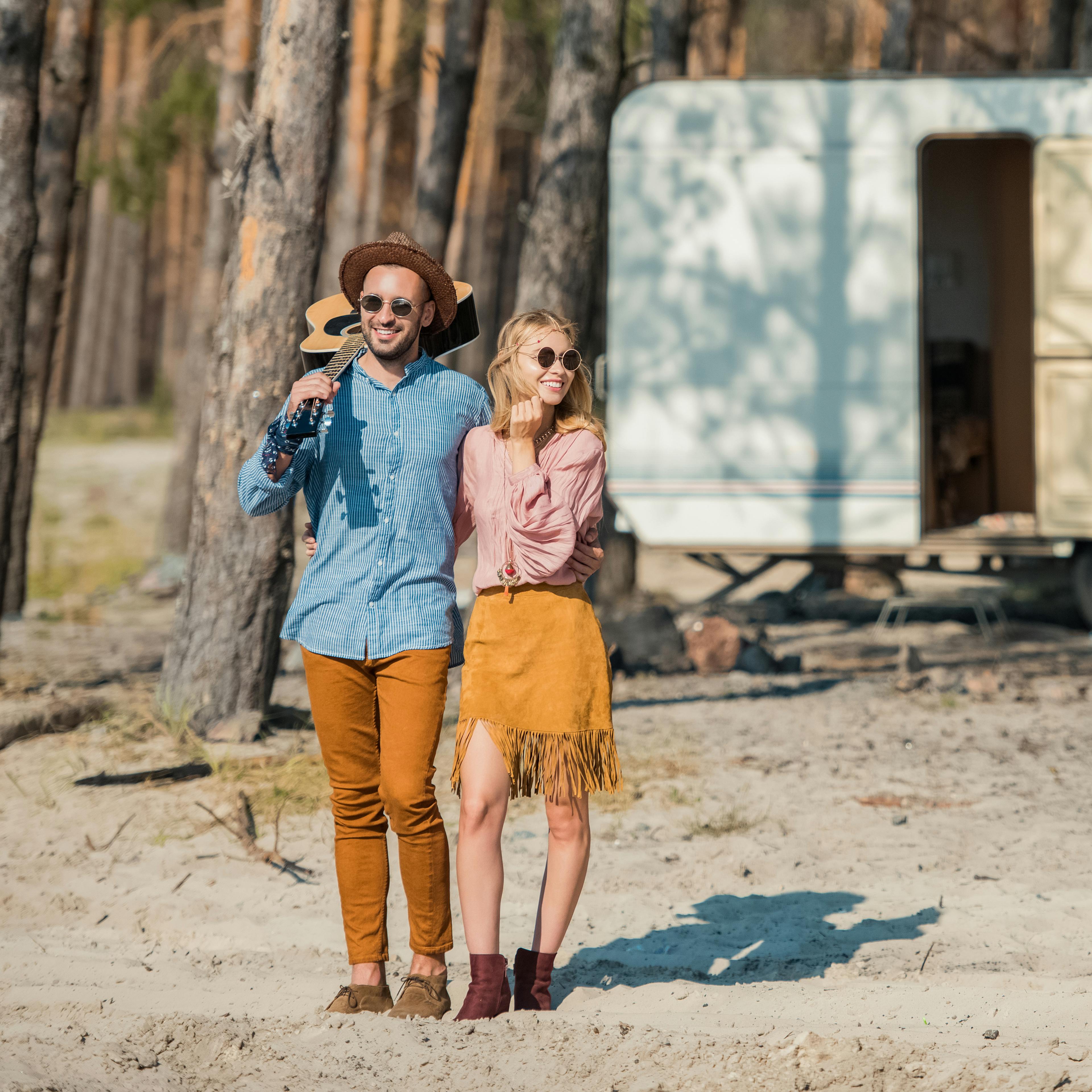 Young hippie couple hugging and standing with guit